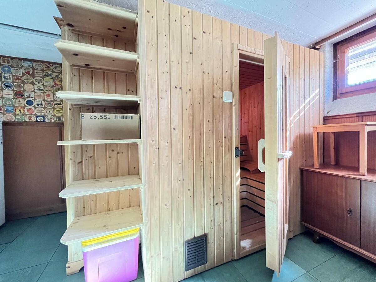Vorbereitungsraum mit Holzregalen und Zugang zu einer privaten Sauna.