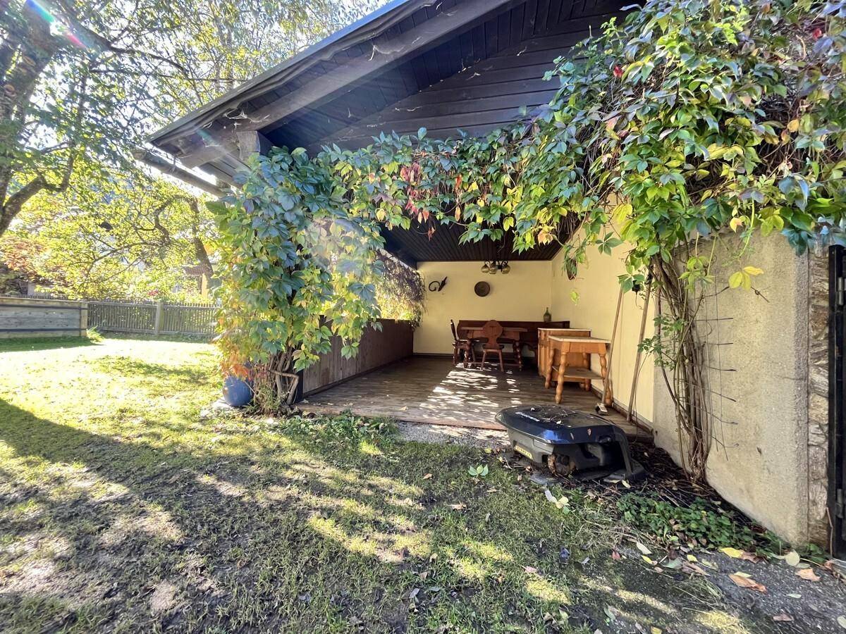 Überdachter Terrassenbereich mit rustikalen Holzmöbeln, ideal für gemütliche Stunden im Freien.