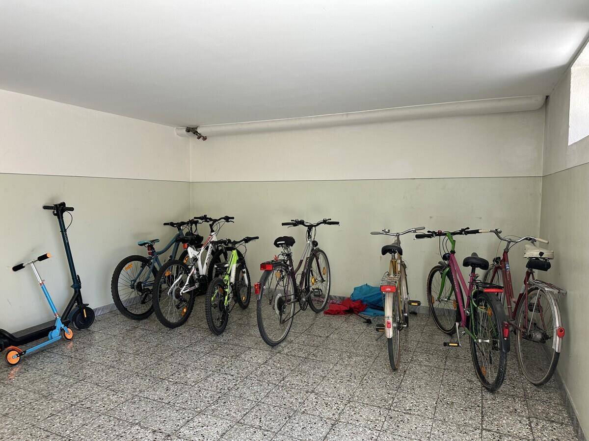 Gemeinschaftlicher Fahrradraum im Keller mit mehreren Fahrrädern und einem Roller.