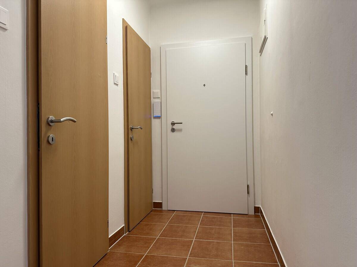 Eingangsbereich mit Fliesenboden und mehreren Türen, darunter die Wohnungseingangstür.