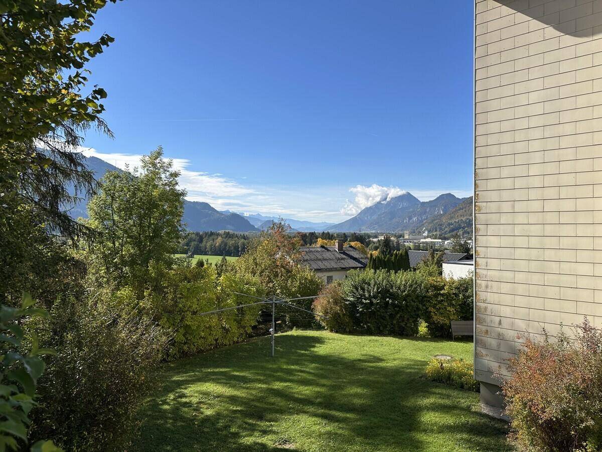 Großer, gepflegter Garten mit Rasenfläche und Bergblick unter blauem Himmel.