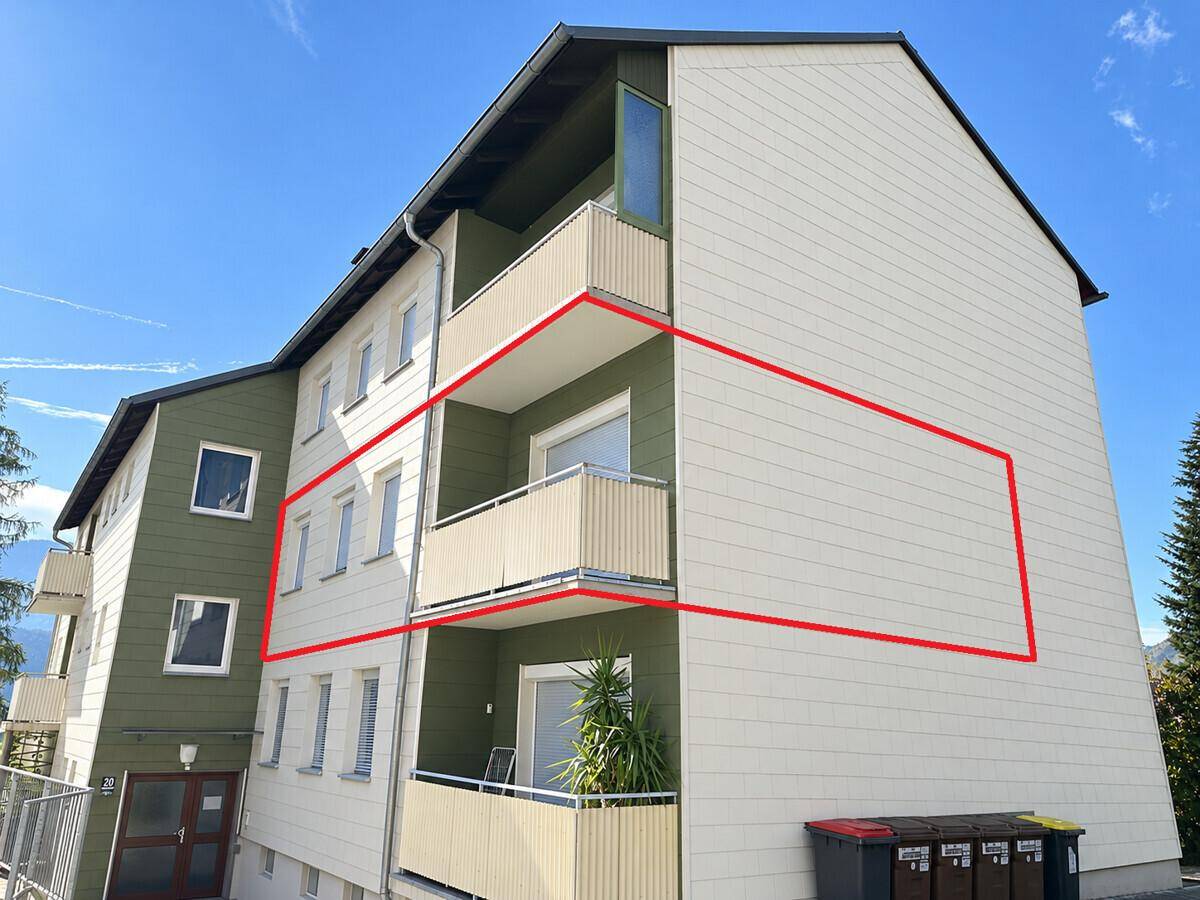 Mehrfamilienhaus mit mehreren Balkonen und einer markierten Fassadenfläche.