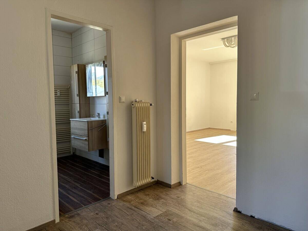 Heller Flur mit Laminatboden und Zugang zu weiteren Zimmern und dem Badezimmer.