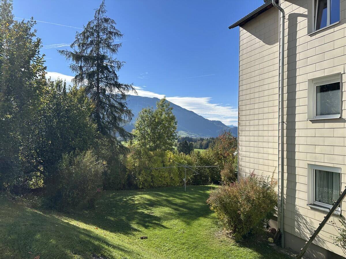 Seitenansicht eines Gebäudes mit Garten und weitem Blick auf die Berglandschaft.