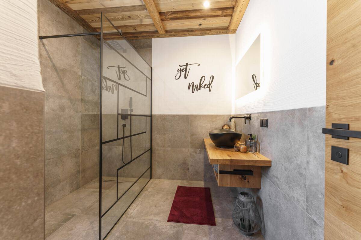 Modernes Badezimmer mit großer begehbarer Dusche und stilvollem Aufsatzwaschbecken.