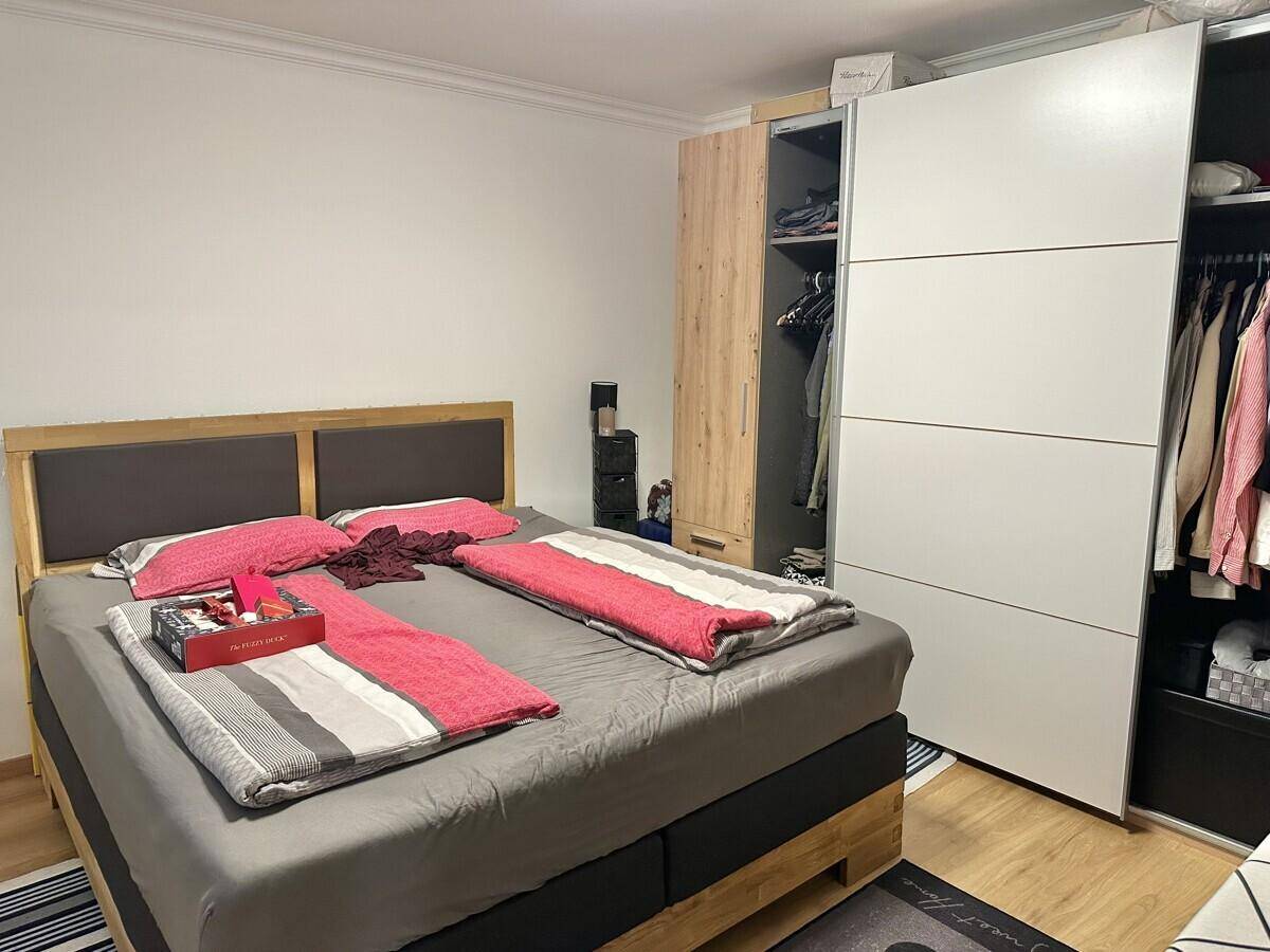 Schlafzimmer mit Doppelbett und großem Schiebetürenschrank.