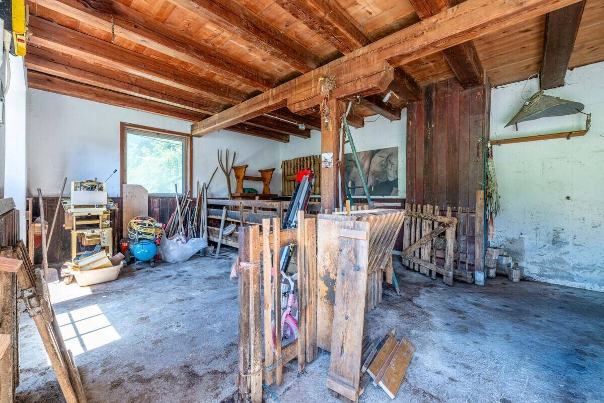 Geräumiger Werkstattbereich mit sichtbaren Holzbalken, Werkzeugen und Geräten.
