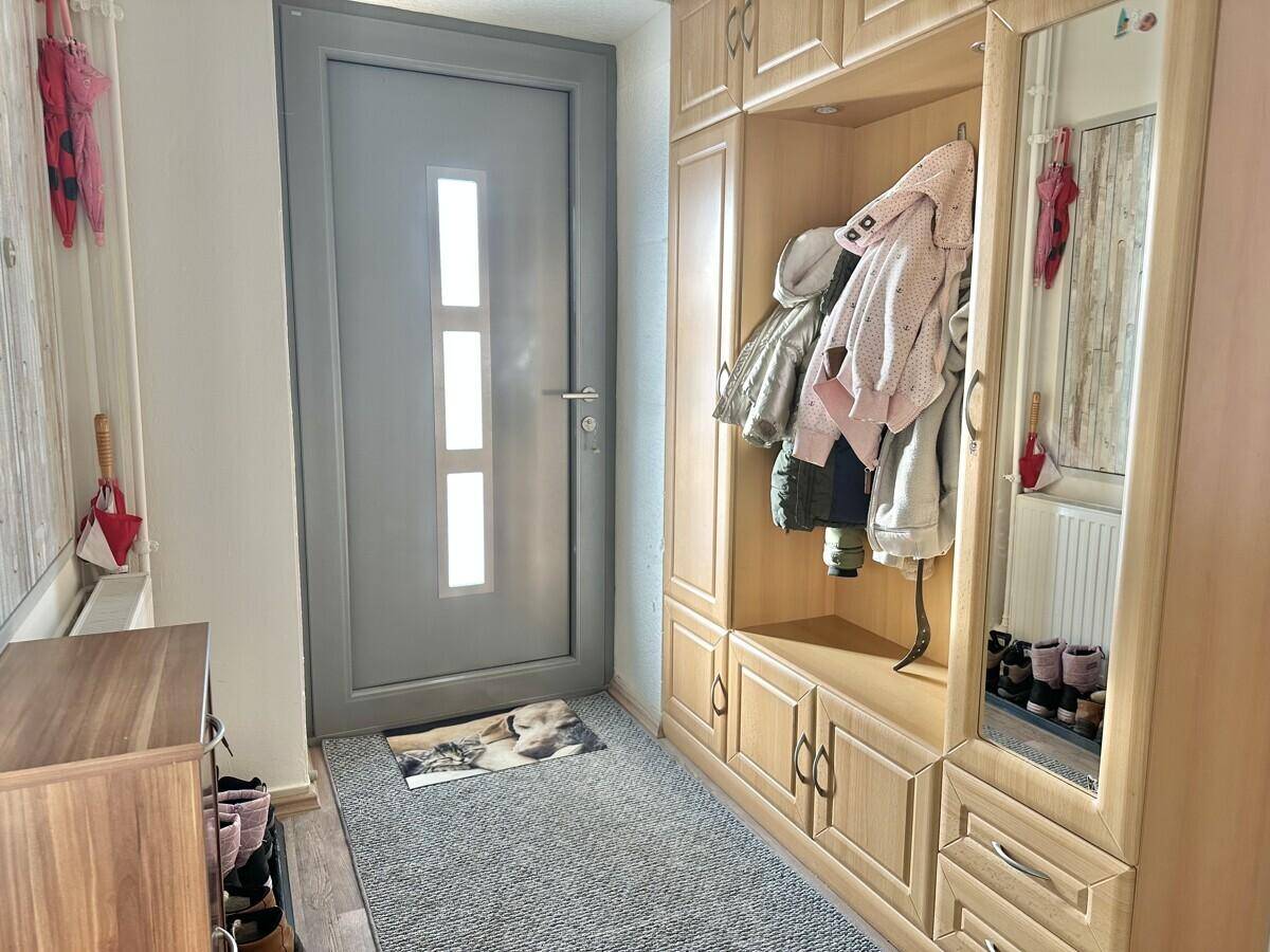 Eingangsbereich mit Einbauschrank, Garderobe und Teppichboden.