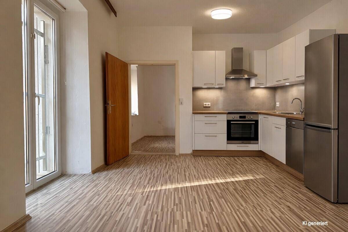 Moderne Einbauküche in Weiß mit Edelstahlelementen und hellem Laminatboden, gut beleuchtet.