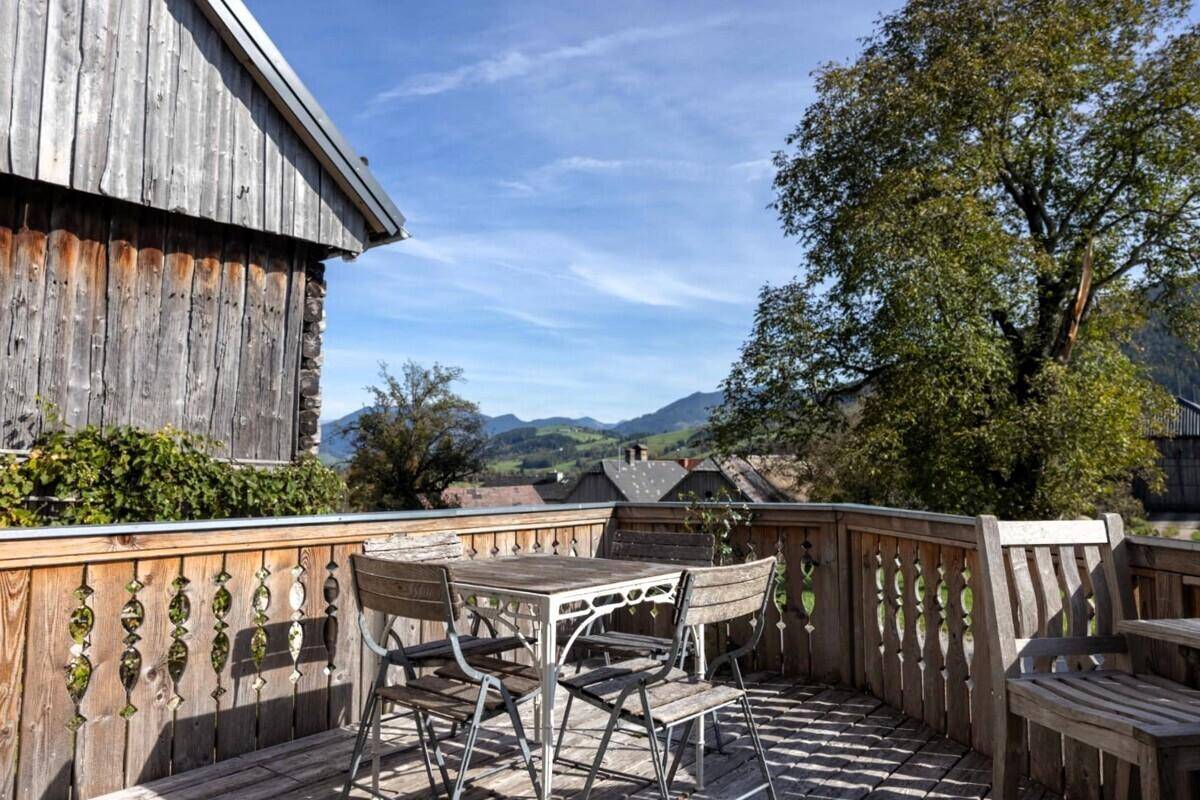 Rustikaler Holzbalkon mit Sitzgelegenheiten und weitem Blick auf die umliegende Landschaft.