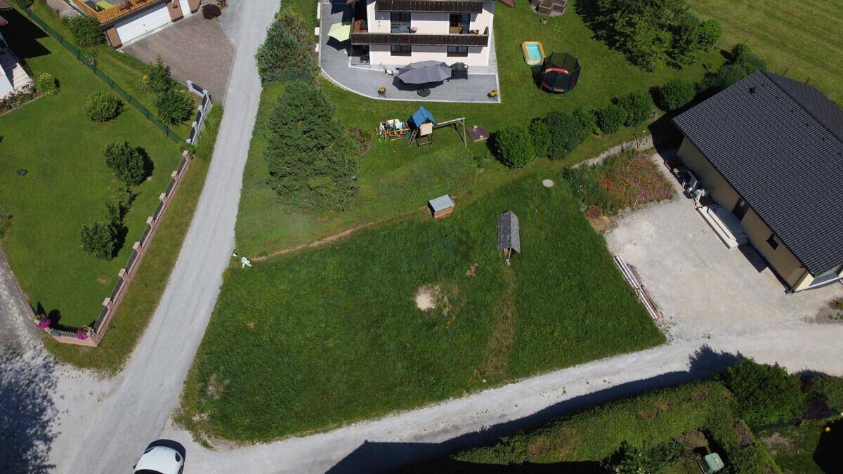 Luftaufnahme eines Grundstücks mit Haus, Rasenfläche und angrenzenden Wegen in ländlicher Umgebung.