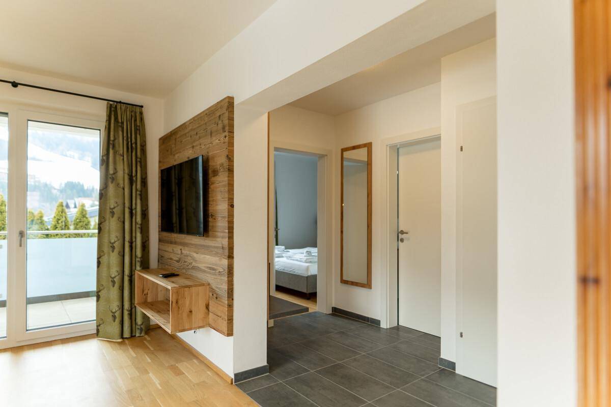 Heller Flur mit Holzboden, Wandverkleidung und Zugang zu weiteren Räumen.