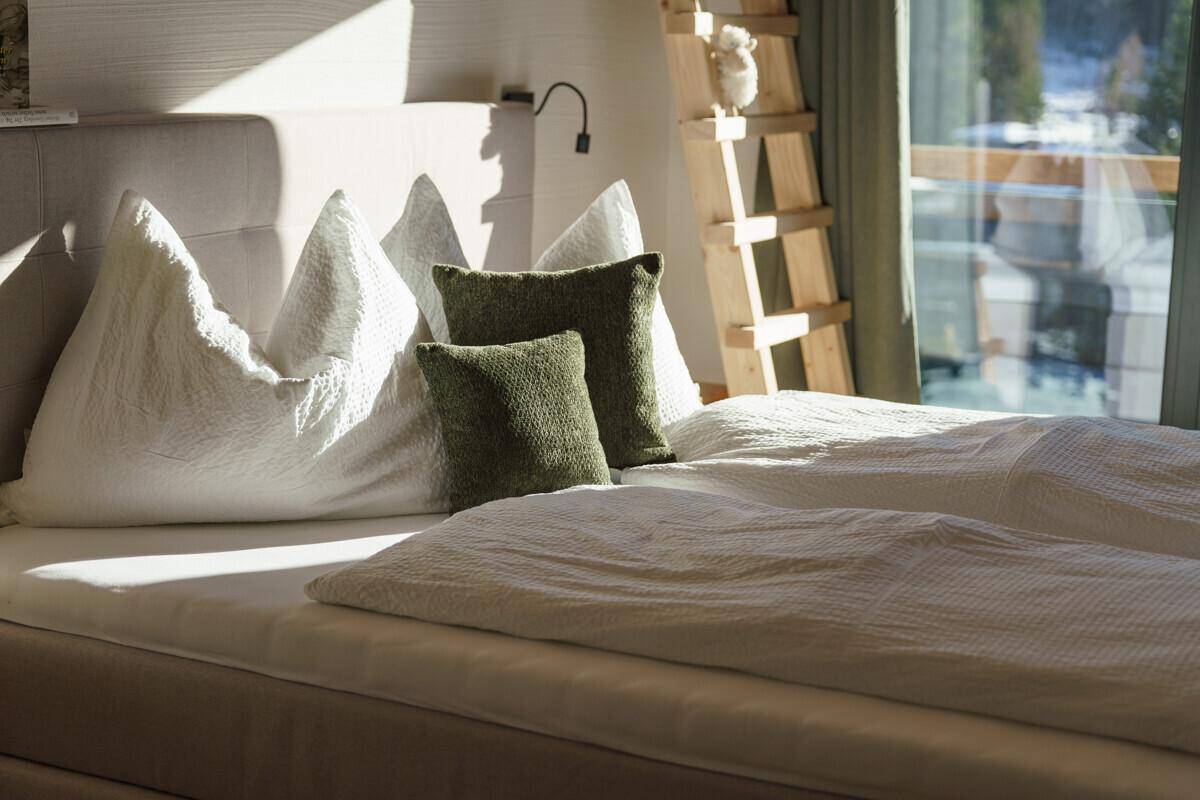 Gemütliches Schlafzimmer mit bequemen Betten, Holzelementen und viel natürlichem Licht.