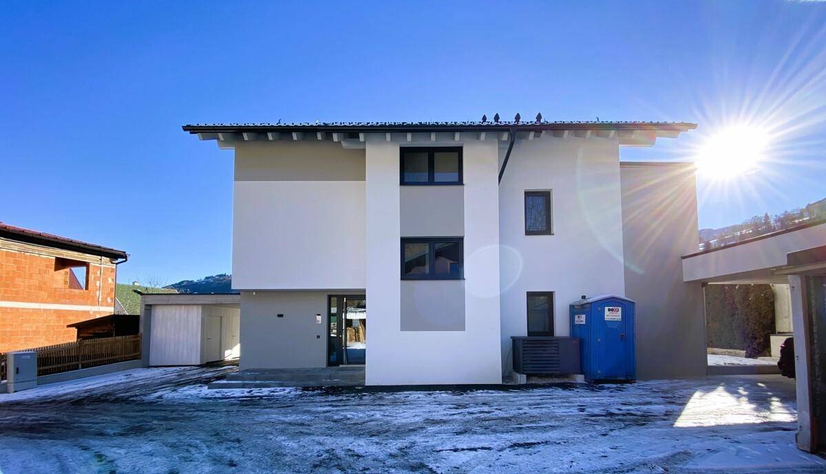 Neubau mit moderner Architektur, Carport und sonniger Lage in den Alpen.