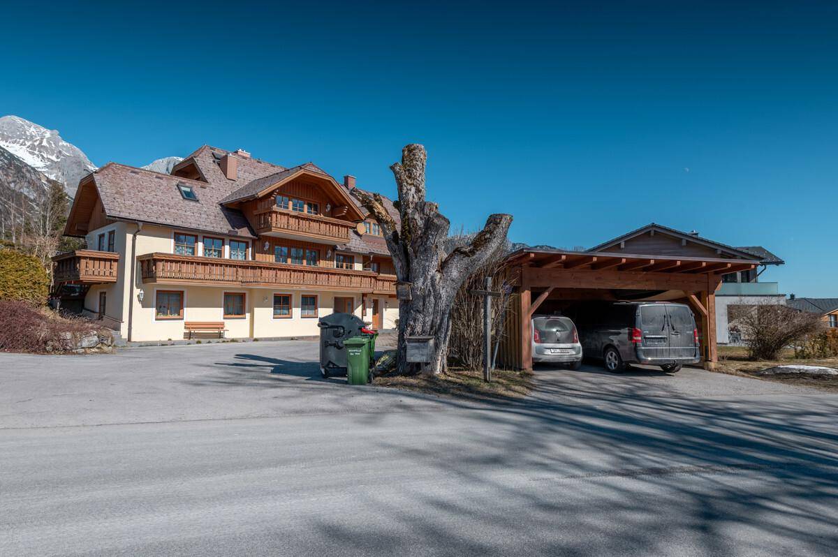 Außenansicht des Hauses mit Carport und beeindruckendem Bergpanorama.