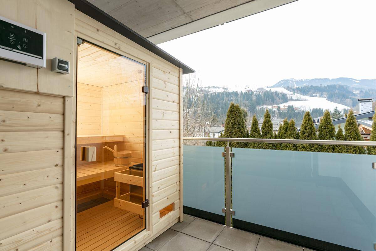 Balkon mit Außensauna und weitem Blick auf die verschneite Berglandschaft.