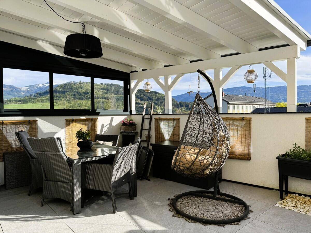 Überdachter Terrassenbereich mit Essgruppe und Hängesessel, ideal für entspannte Stunden.