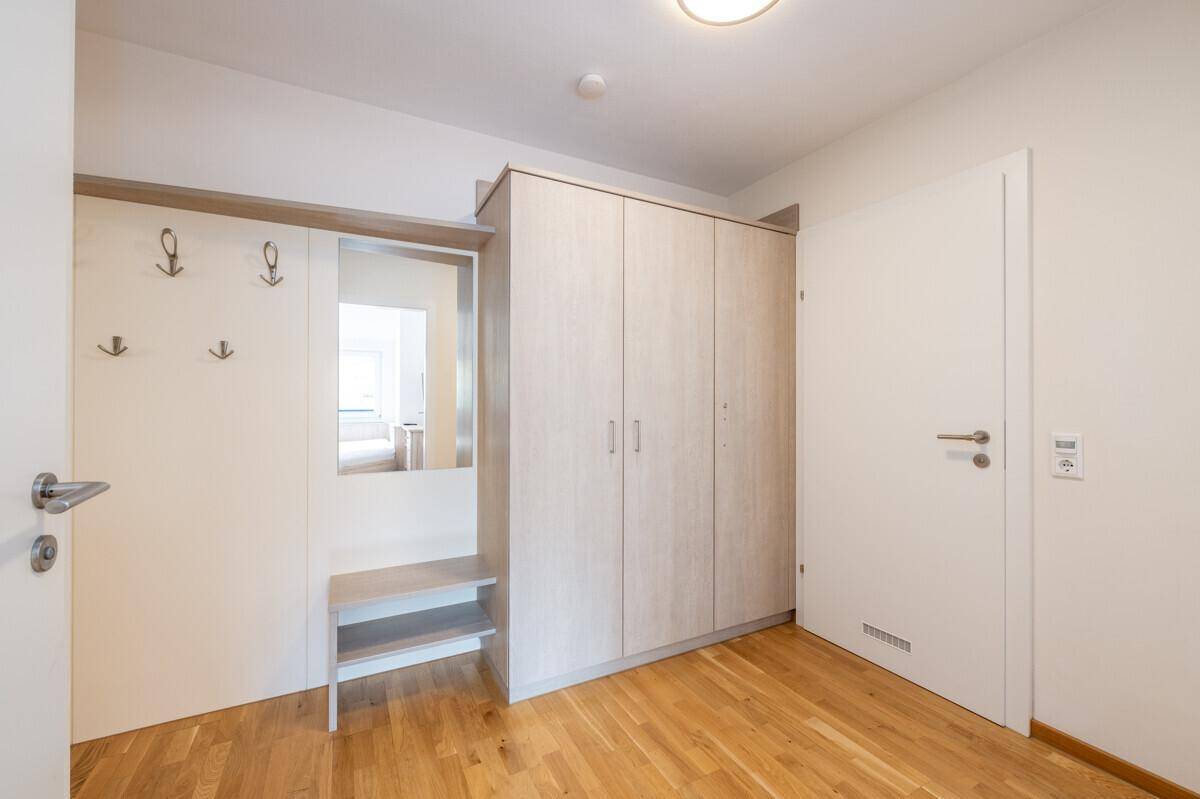 Eingangsbereich mit praktischen Einbauschränken, Garderobe und hellem Holzfußboden.