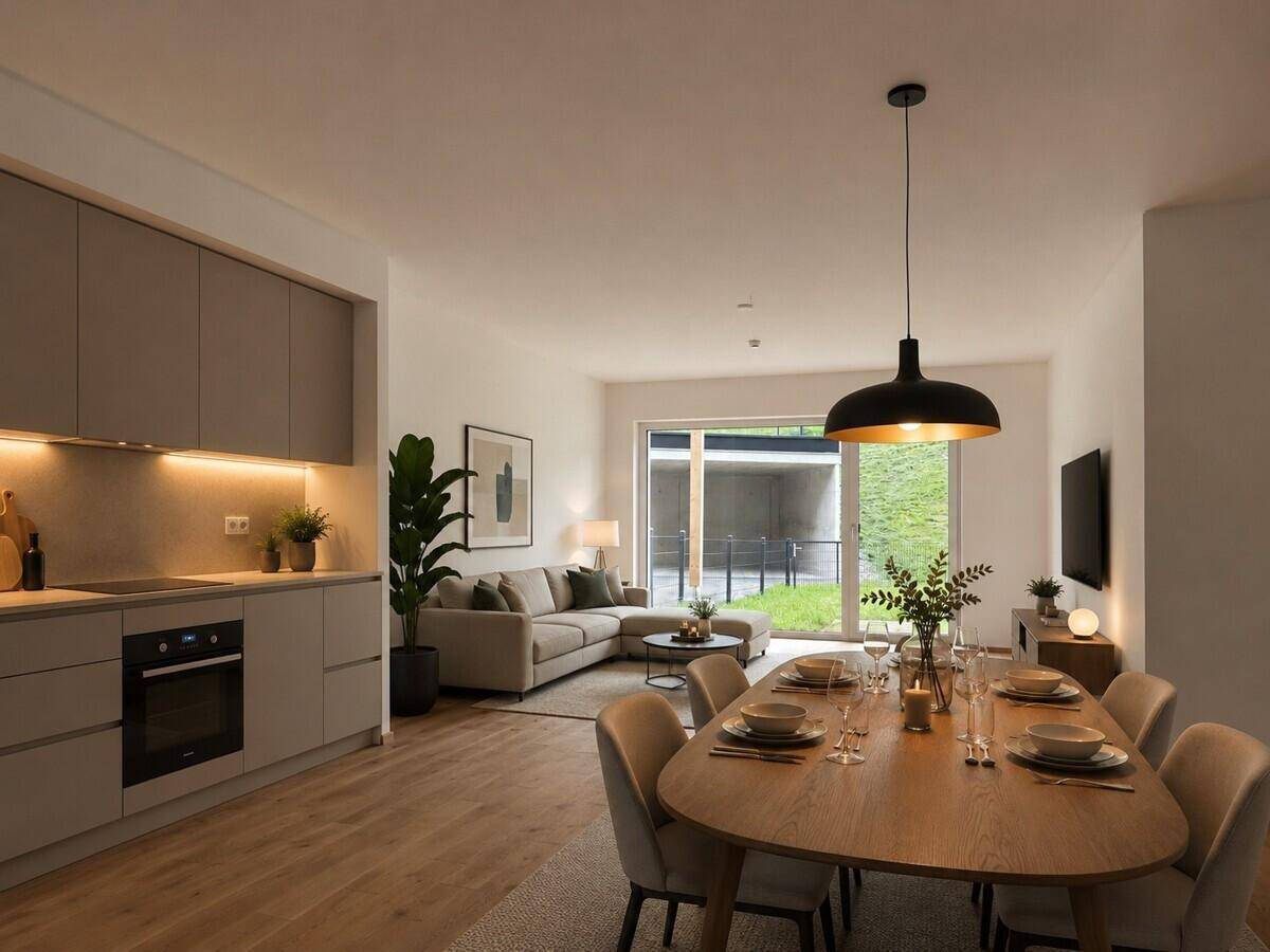 Heller offener Wohn-Essbereich mit moderner Einbauküche, Holzboden und Zugang zum Garten.