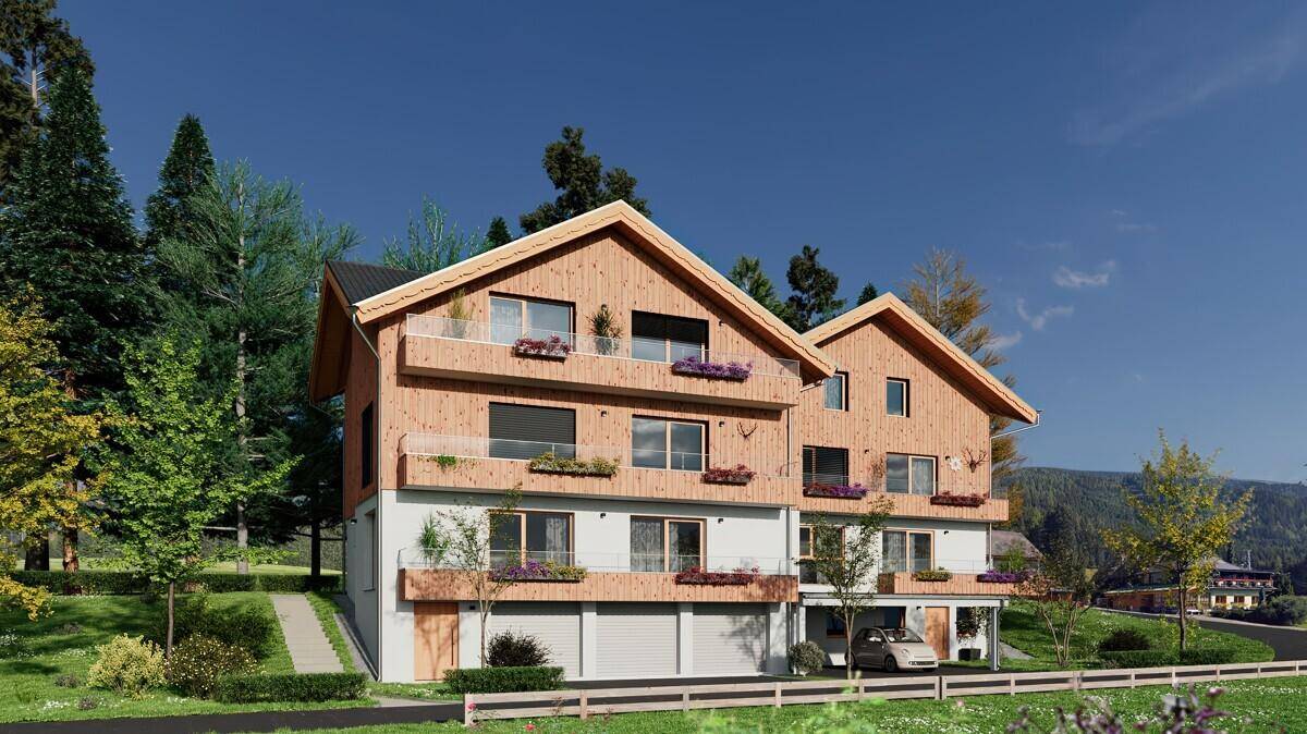 Neubau im Chalet-Stil mit Holzfassade, Balkonen und Carport in einer idyllischen Umgebung.