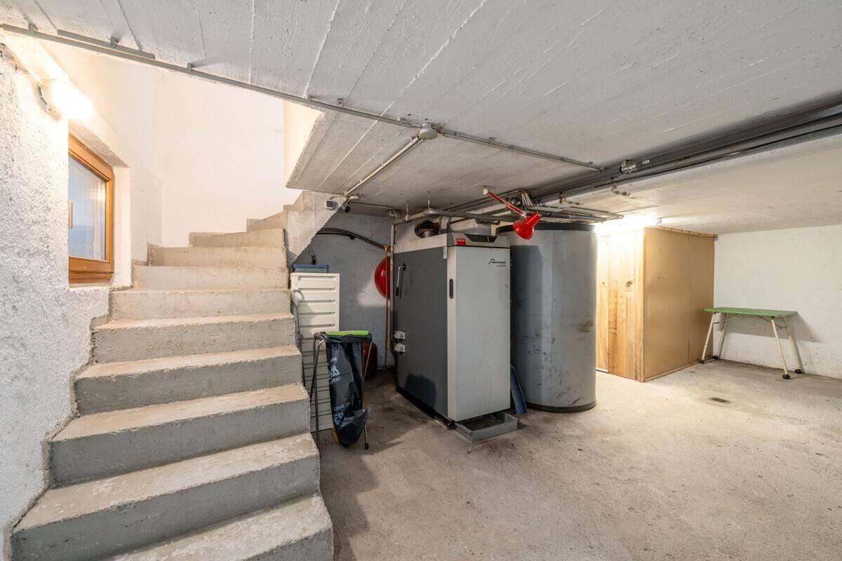 Kellerraum mit Heizungsanlage und Warmwasserspeicher, mit Betontreppe.