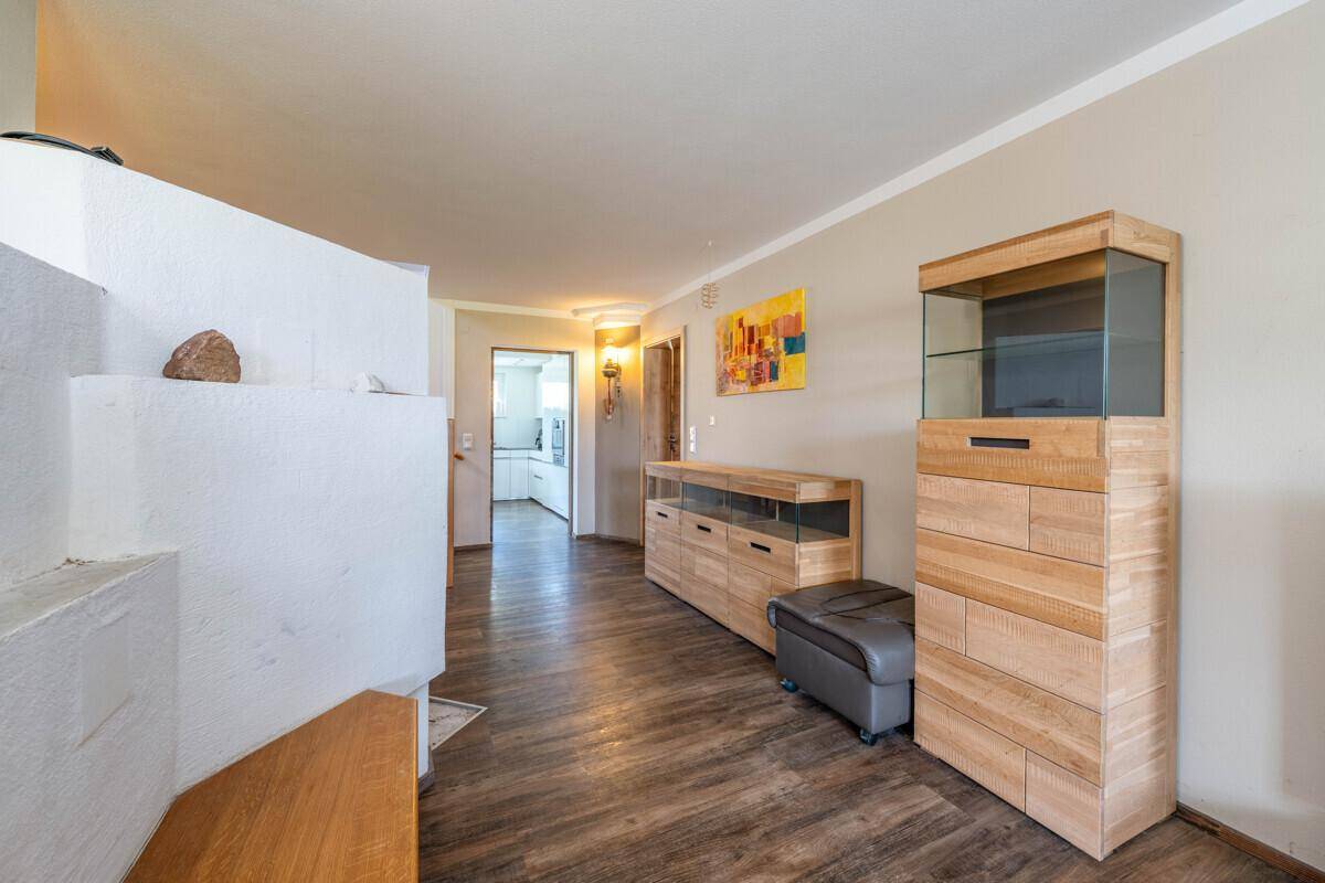 Heller Flur mit Holzboden, modernem Holzmöbel und Zugang zu weiteren Räumen.