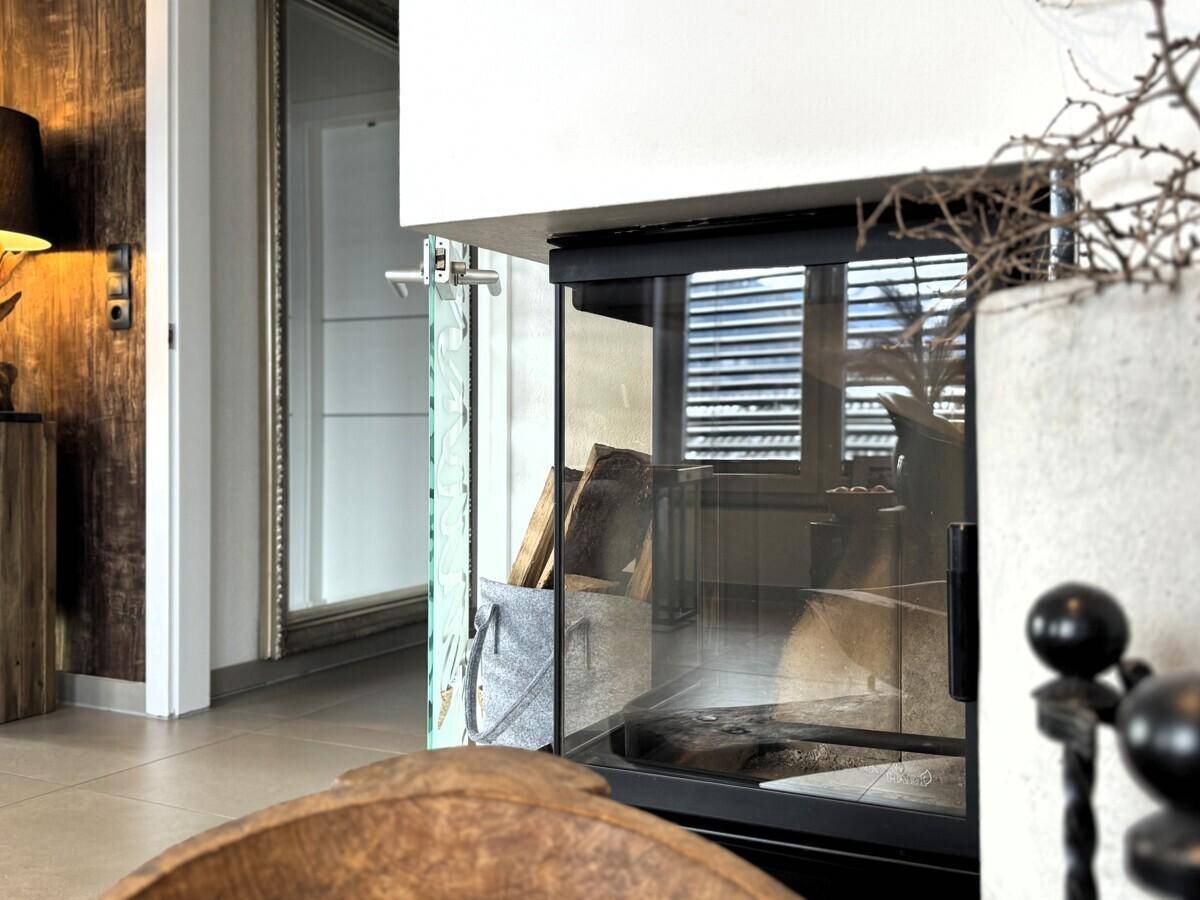 Moderner Kamin mit Holzscheiten und stilvoller Einrichtung für gemütliche Stunden.
