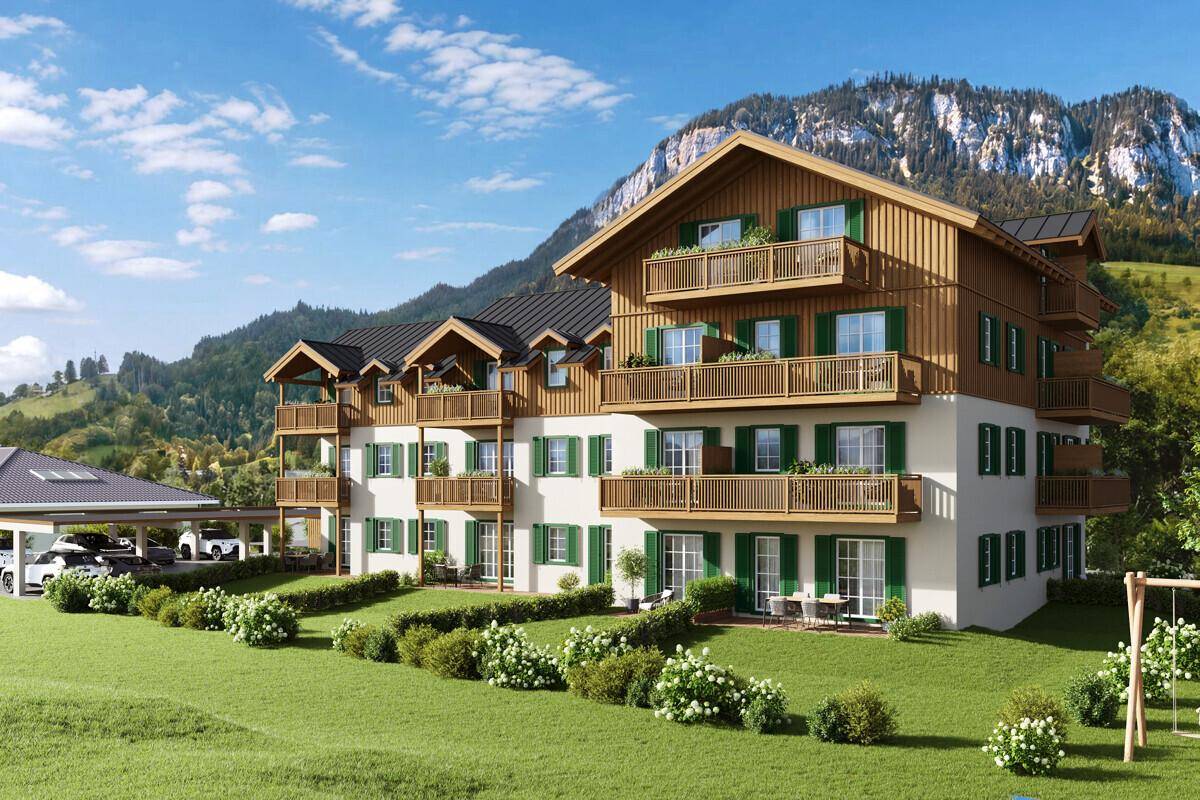 Attraktives Mehrfamilienhaus im alpinen Stil mit Balkonen, Garten und Bergblick.