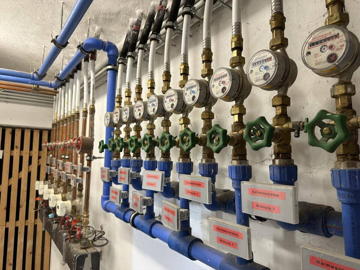 Installationen für Wasserzähler und Rohre in einem Technikraum des Gebäudes.