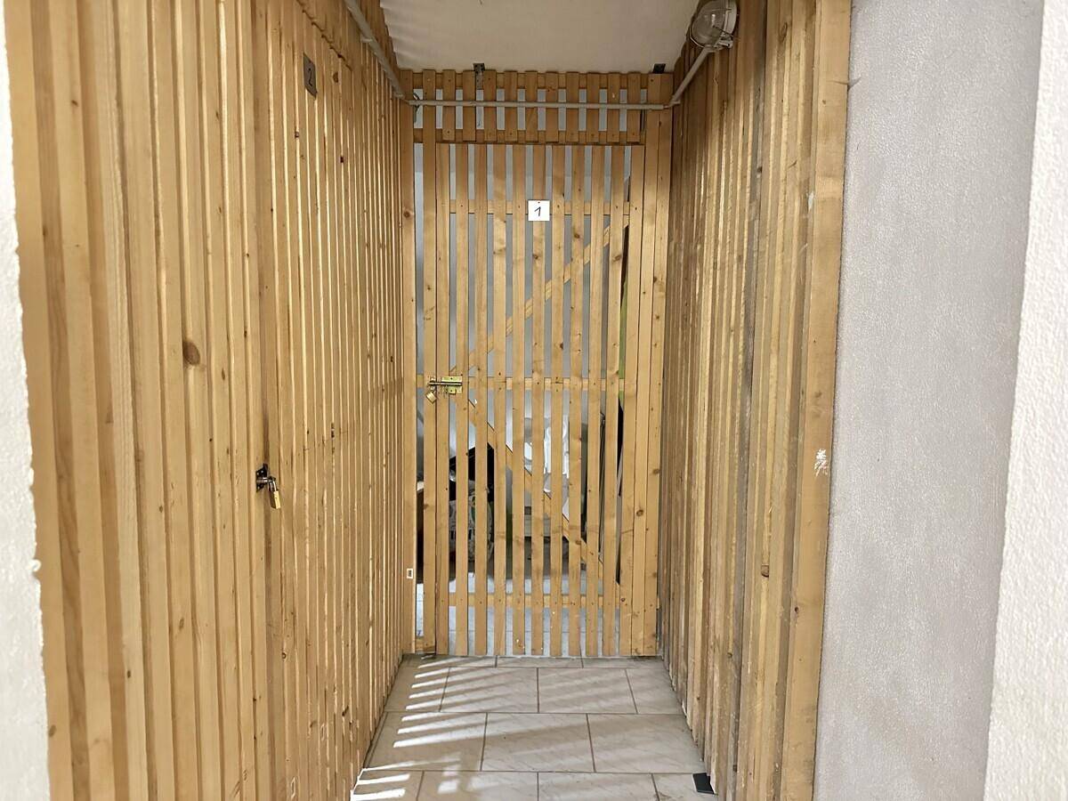 Weitere abgetrennte Lagerbereiche mit Holzlattenwänden und Fliesenboden im Keller.