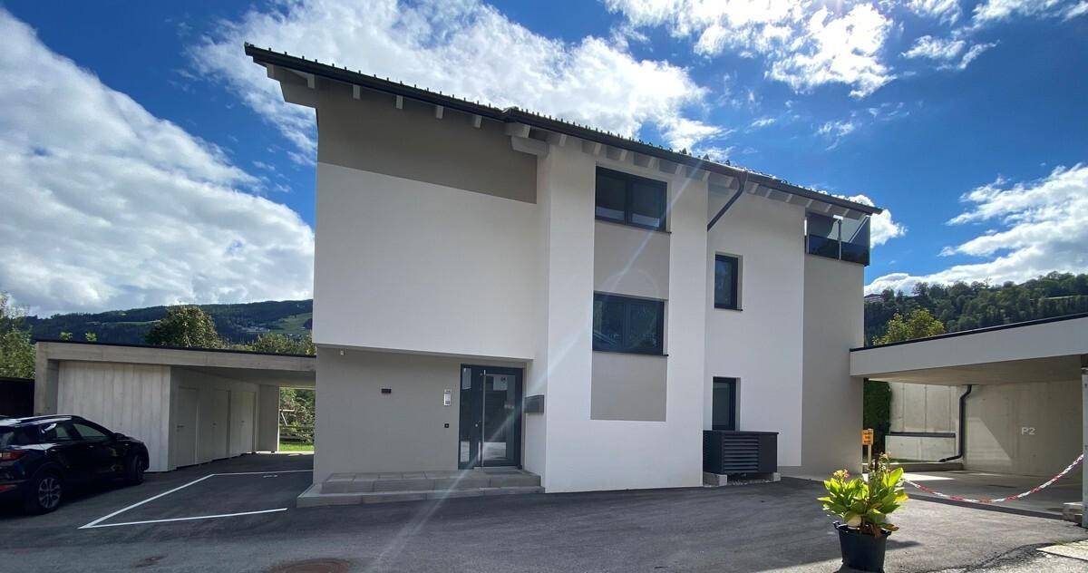 Modernes Mehrfamilienhaus mit Carports und gepflegter Außenanlage in sonniger Lage.