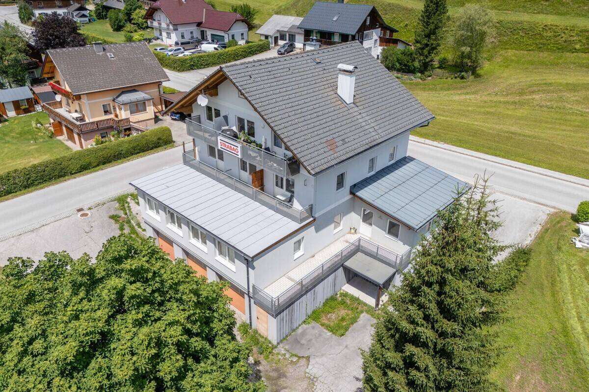 Gebäudeansicht von oben mit Balkonen und der umliegenden Berglandschaft.