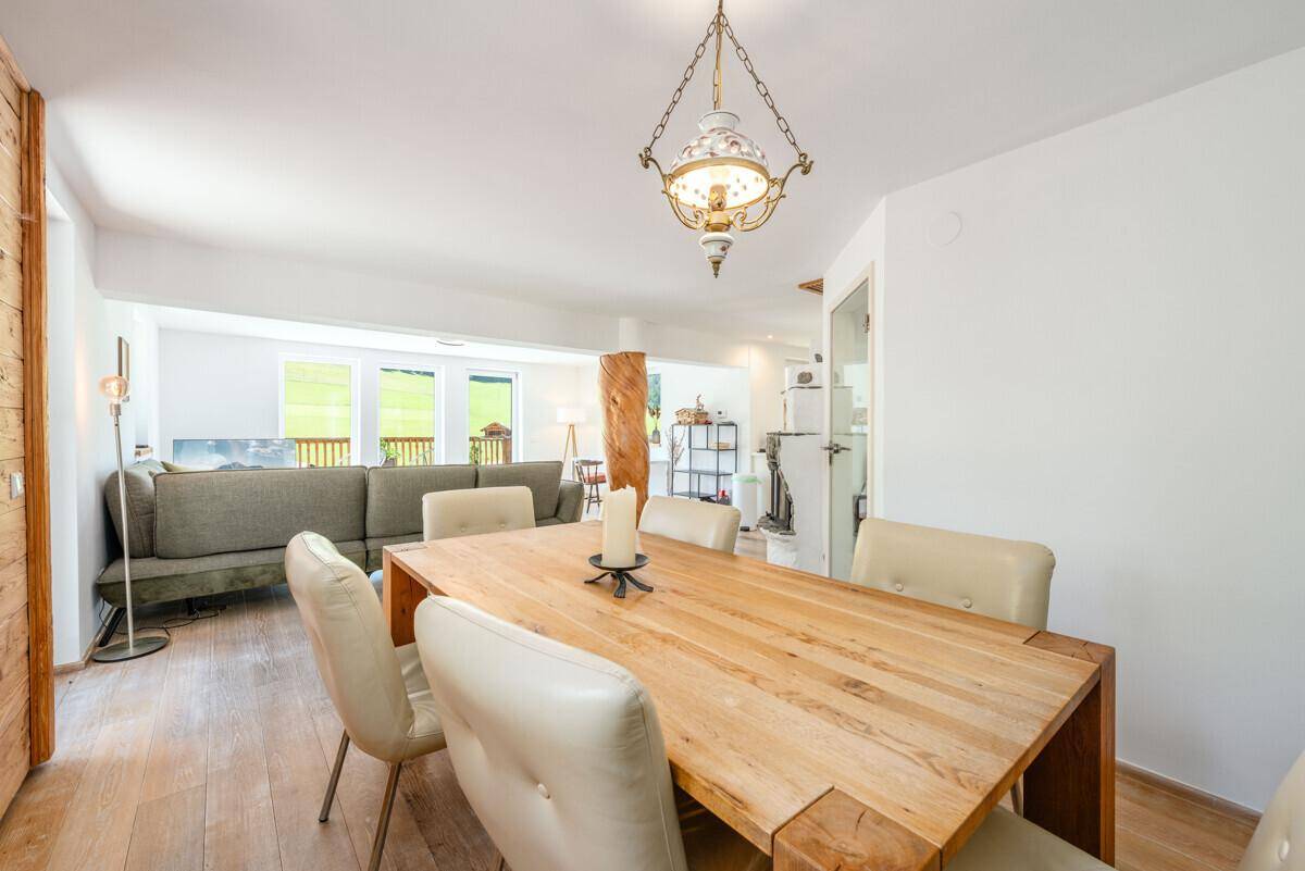 Heller Essbereich mit Holztisch und Stühlen, offen zum Wohnzimmer und zur Küche.