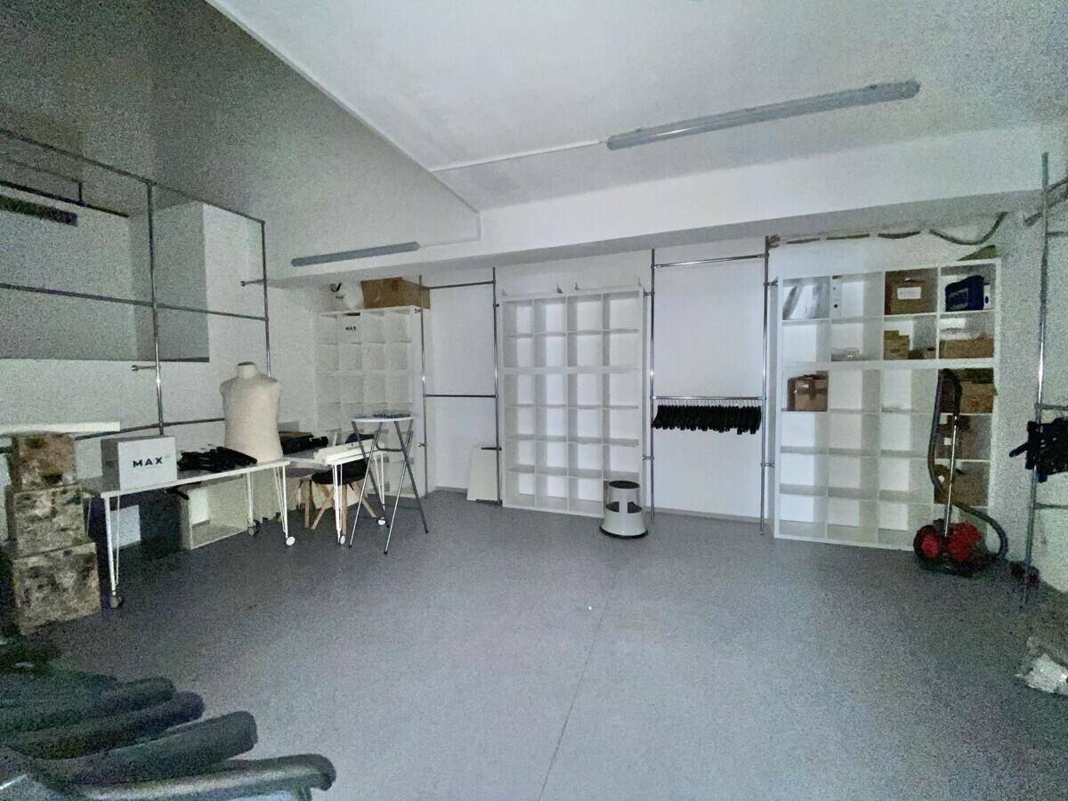 Funktionaler Lagerraum mit Regalen, Arbeitsflächen und Platz für Waren oder Büromaterialien.