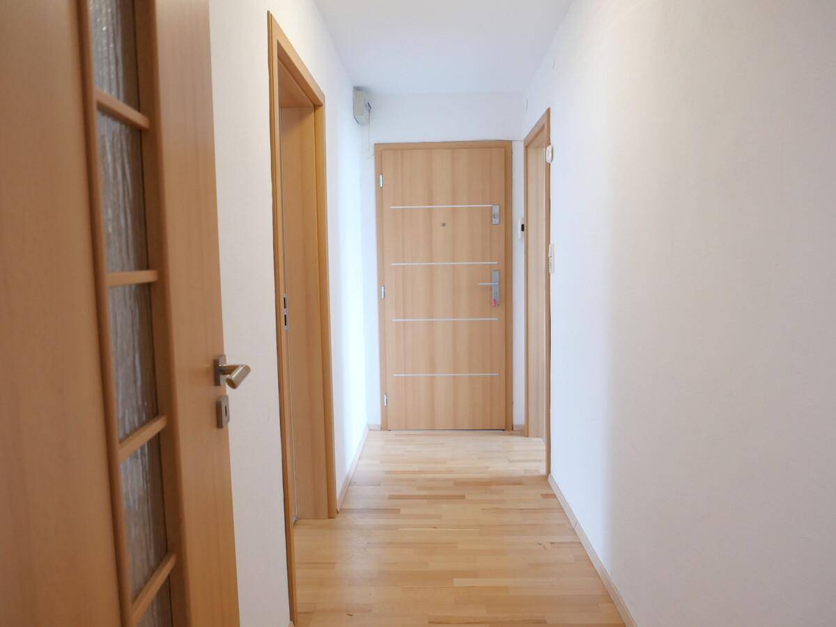 Heller Flur mit Holztüren und Parkettboden, der zu den verschiedenen Räumen führt.
