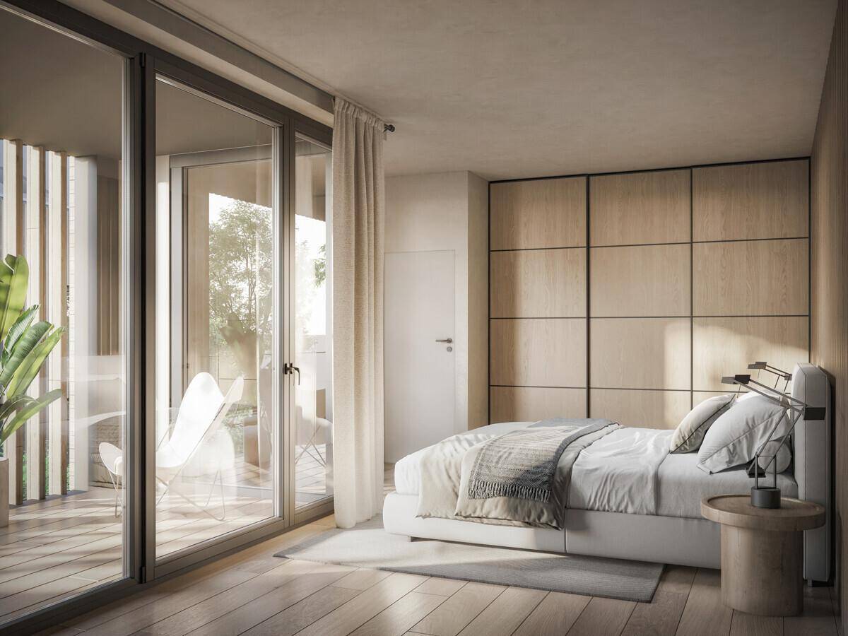 Helles Schlafzimmer mit Holzboden, Einbauschränken und direktem Zugang zu einem Balkon.