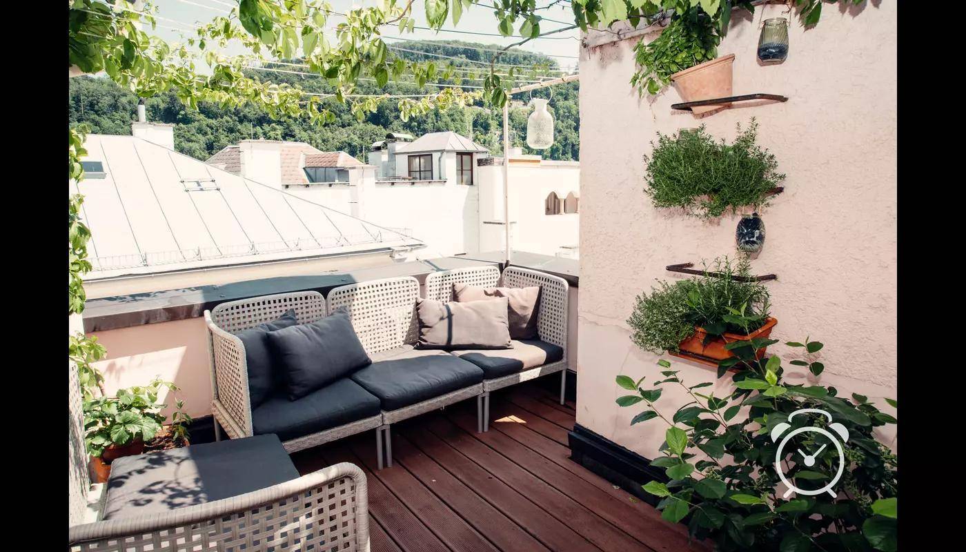 Sonnige Dachterrasse mit bequemen Sitzmöbeln und Pflanzen.
