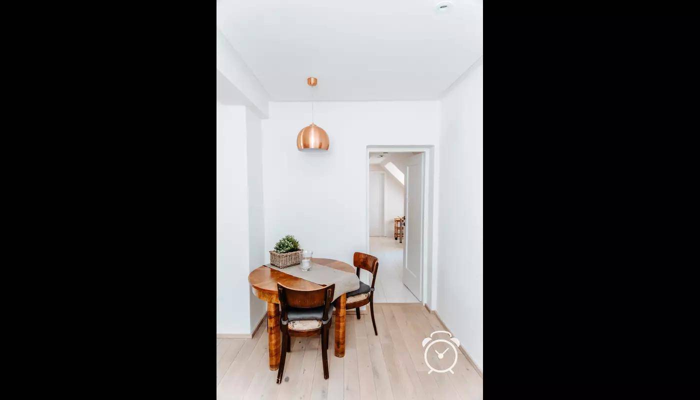 Gemütlicher Essbereich mit rundem Holztisch und zwei Stühlen.