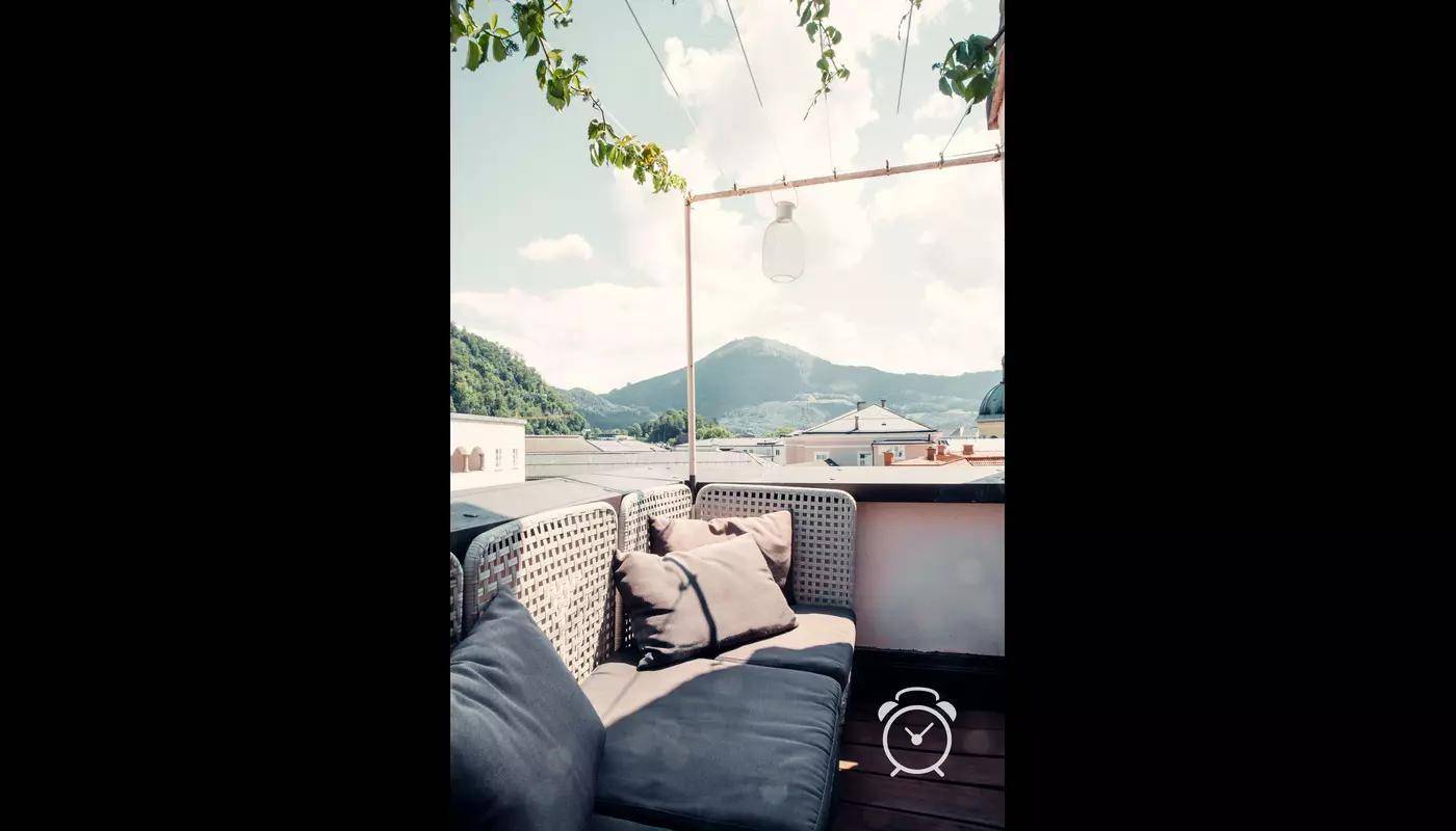 Dachterrasse mit Sitzgelegenheiten und weitem Blick auf die Berge.