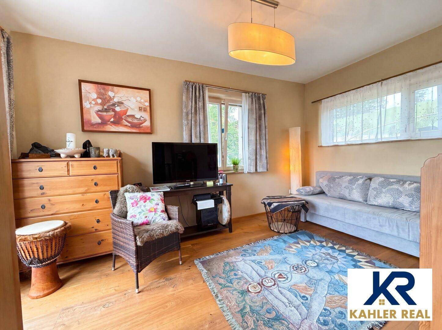 Gemütliches Schlafzimmer mit Holzboden, Kommode und Sofa, ideal als Gästezimmer.