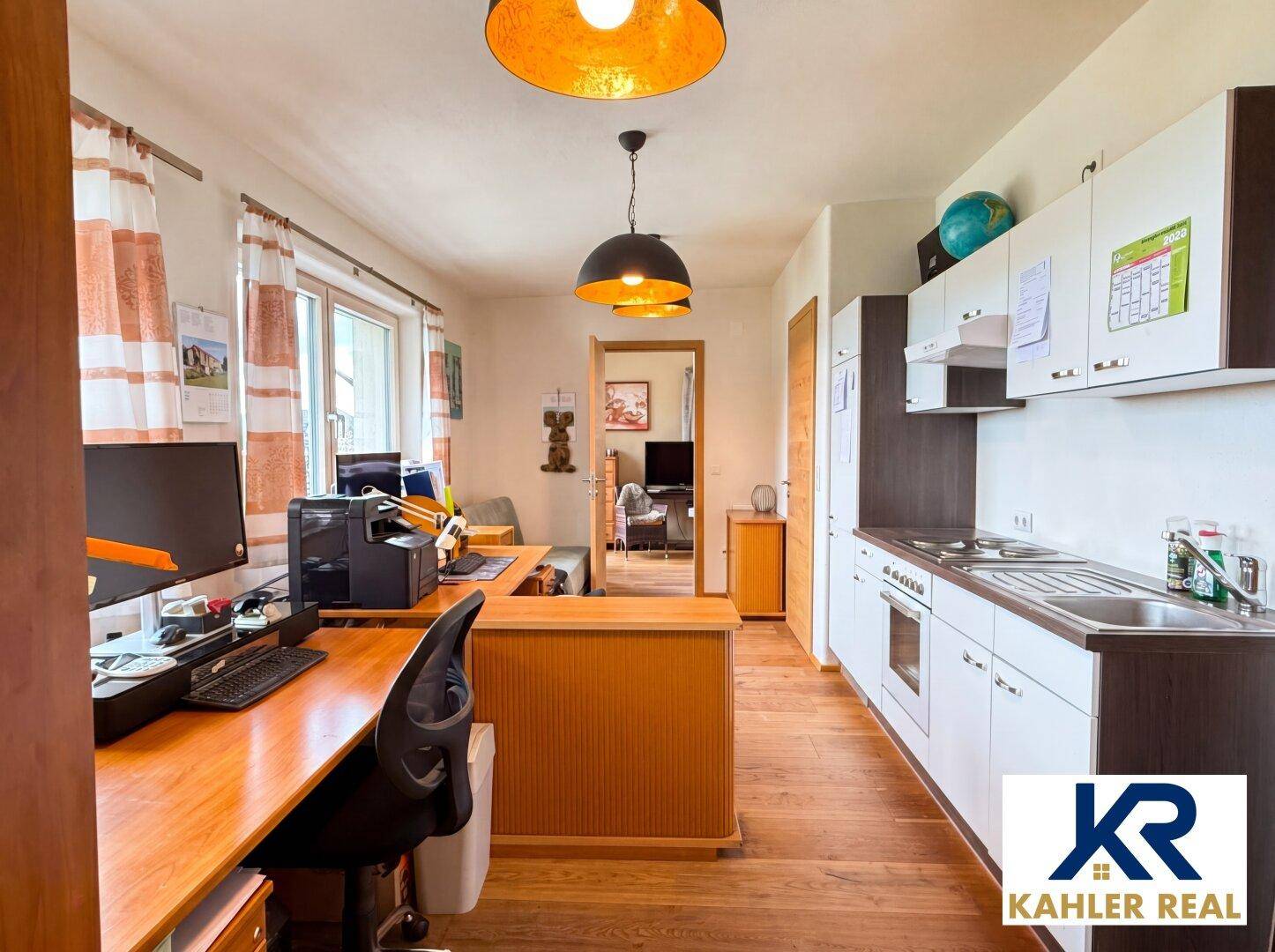 Funktionales Büro mit Küchenzeile, Holzboden und Blick ins Grüne, ideal für Home-Office.