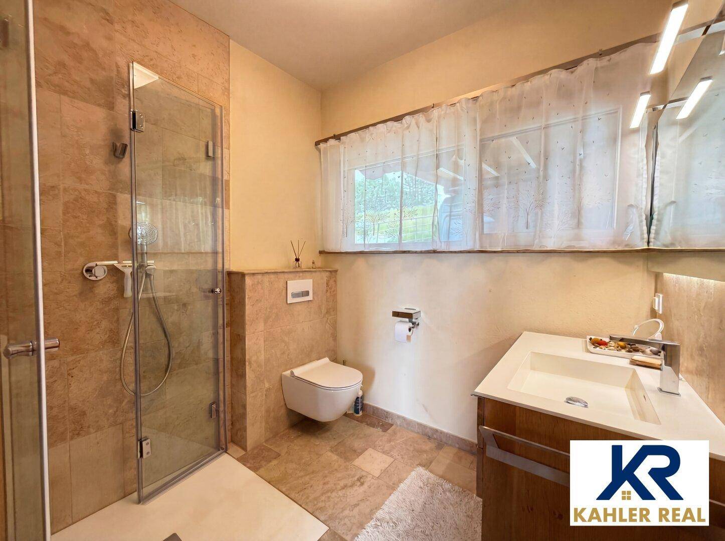 Modernes Badezimmer mit Dusche, wandhängendem WC und Fenster für natürliche Belüftung.