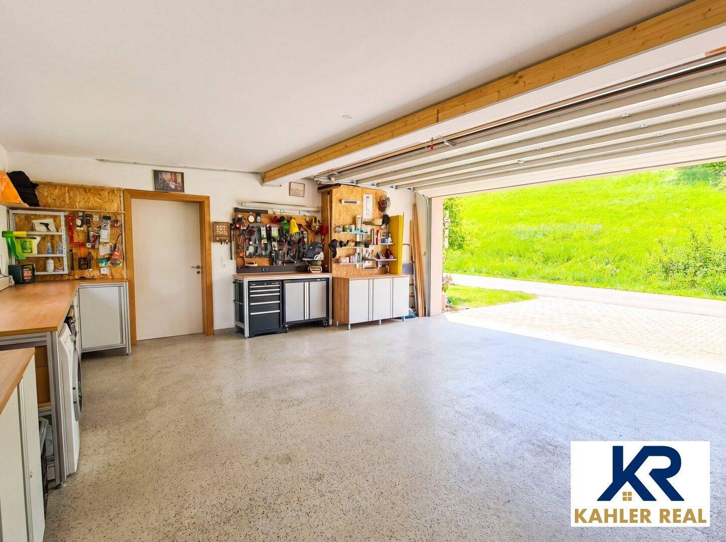 Geräumige Doppelgarage mit Werkstattbereich und direktem Zugang ins Freie.