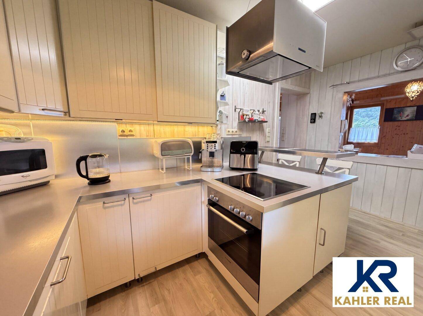 Helle Küche mit modernen Geräten, Kochfeld und Dunstabzugshaube, ideal zum Kochen.