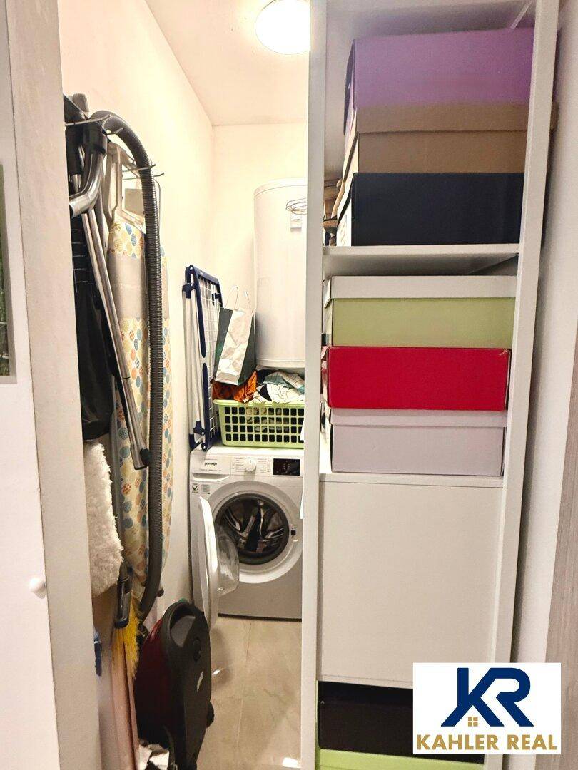 Praktischer Hauswirtschaftsraum mit Waschmaschine, Trockengestell und zusätzlichen Ablagemöglichkeiten.
