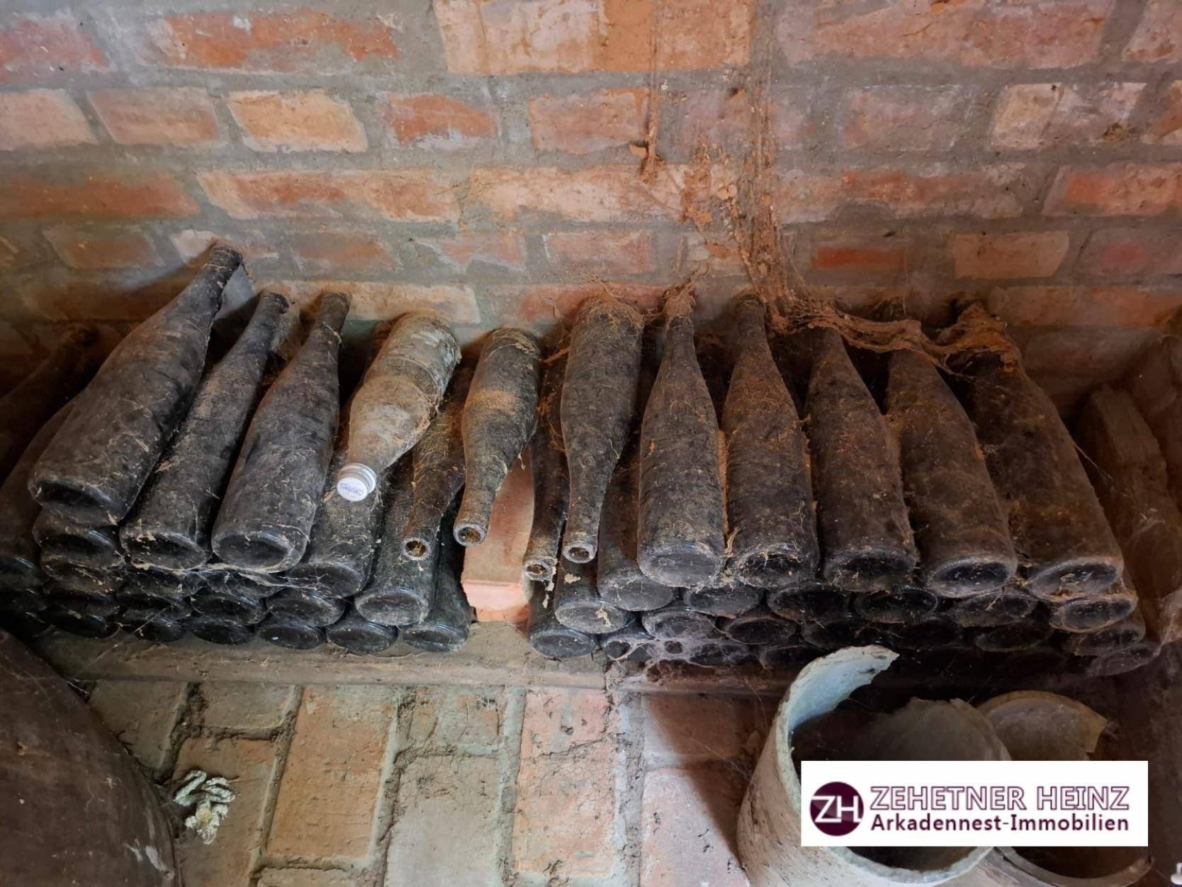 Historischer Weinkeller mit alten Flaschen und Ziegelgewölbe.