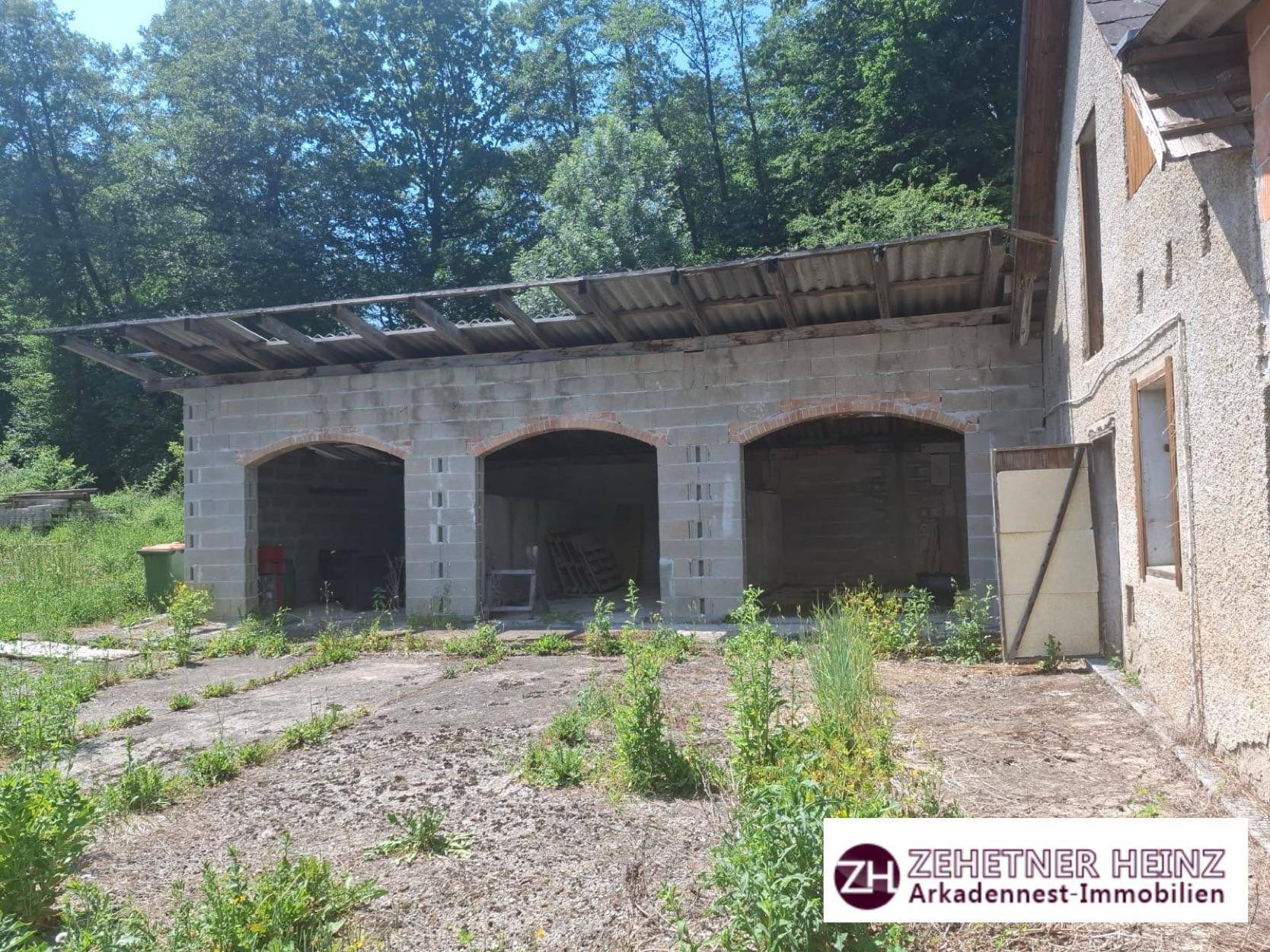 Unfertiges Gebäude mit drei Bogenöffnungen aus Betonblöcken und einem provisorischen Dach.
