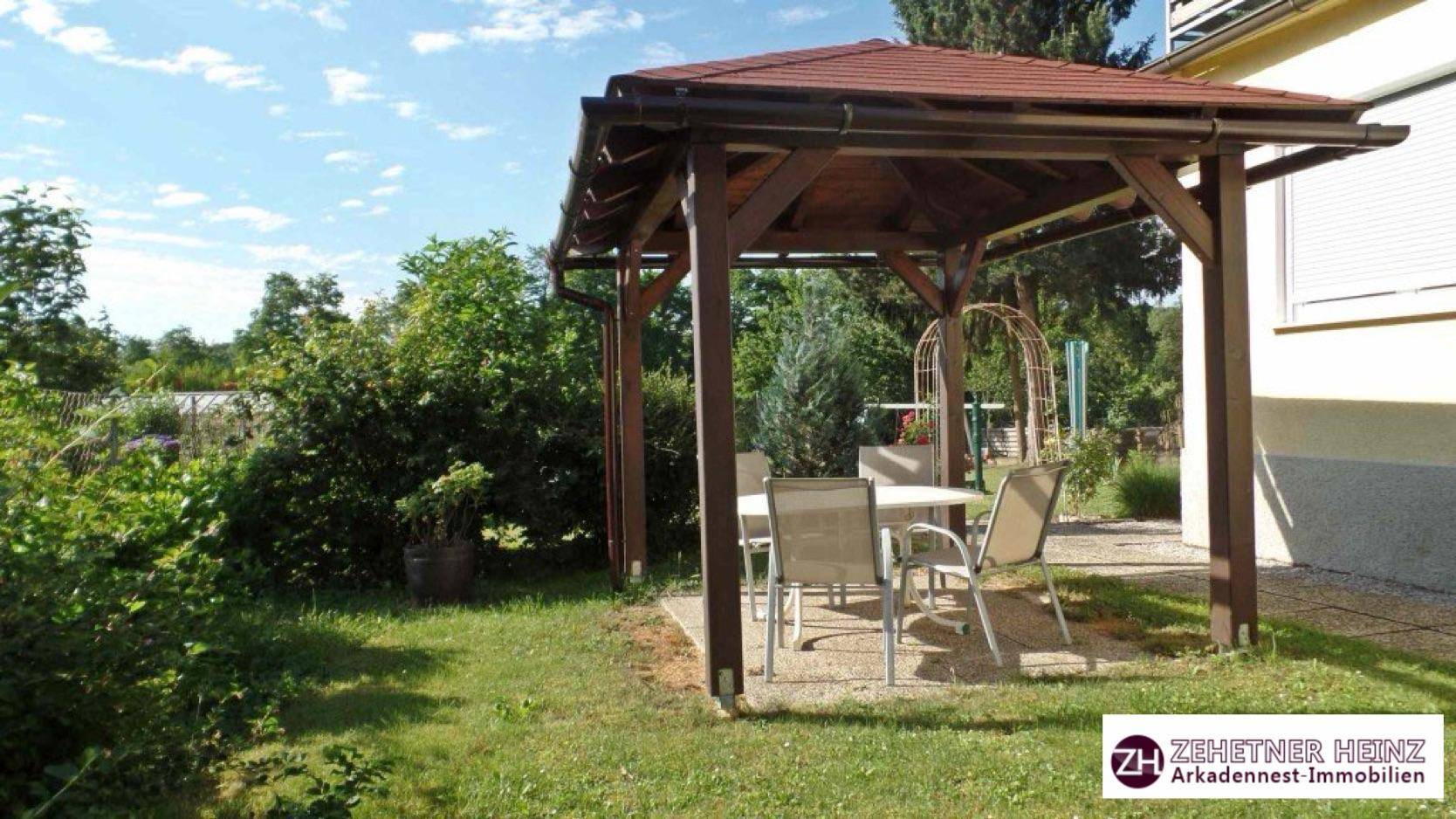 Hölzerner Pavillon mit Gartenmöbeln, ideal für entspannte Stunden im Grünen.