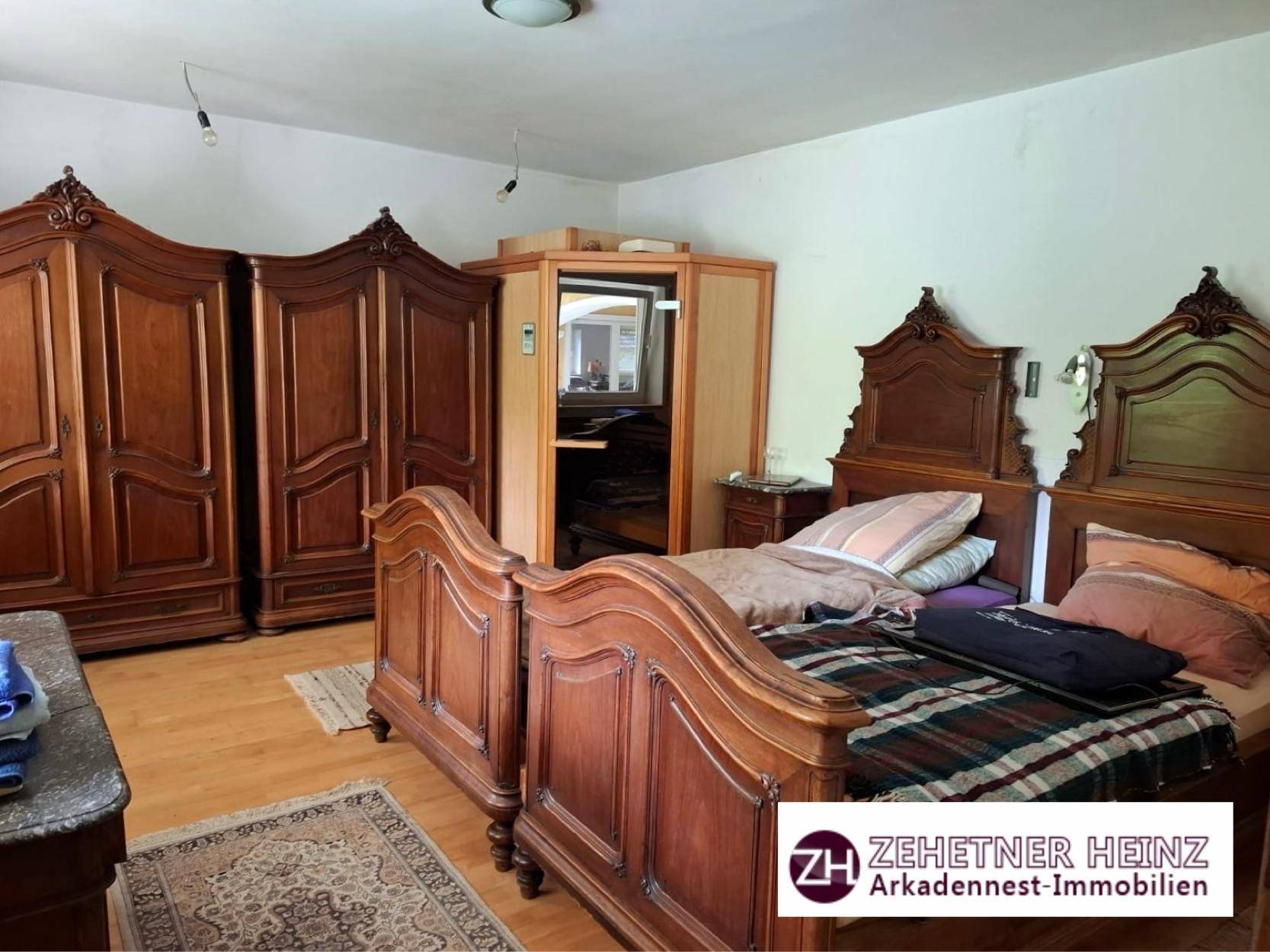 Schlafzimmer mit traditionellen Holzmöbeln, Holzboden und Infrarotkabine.