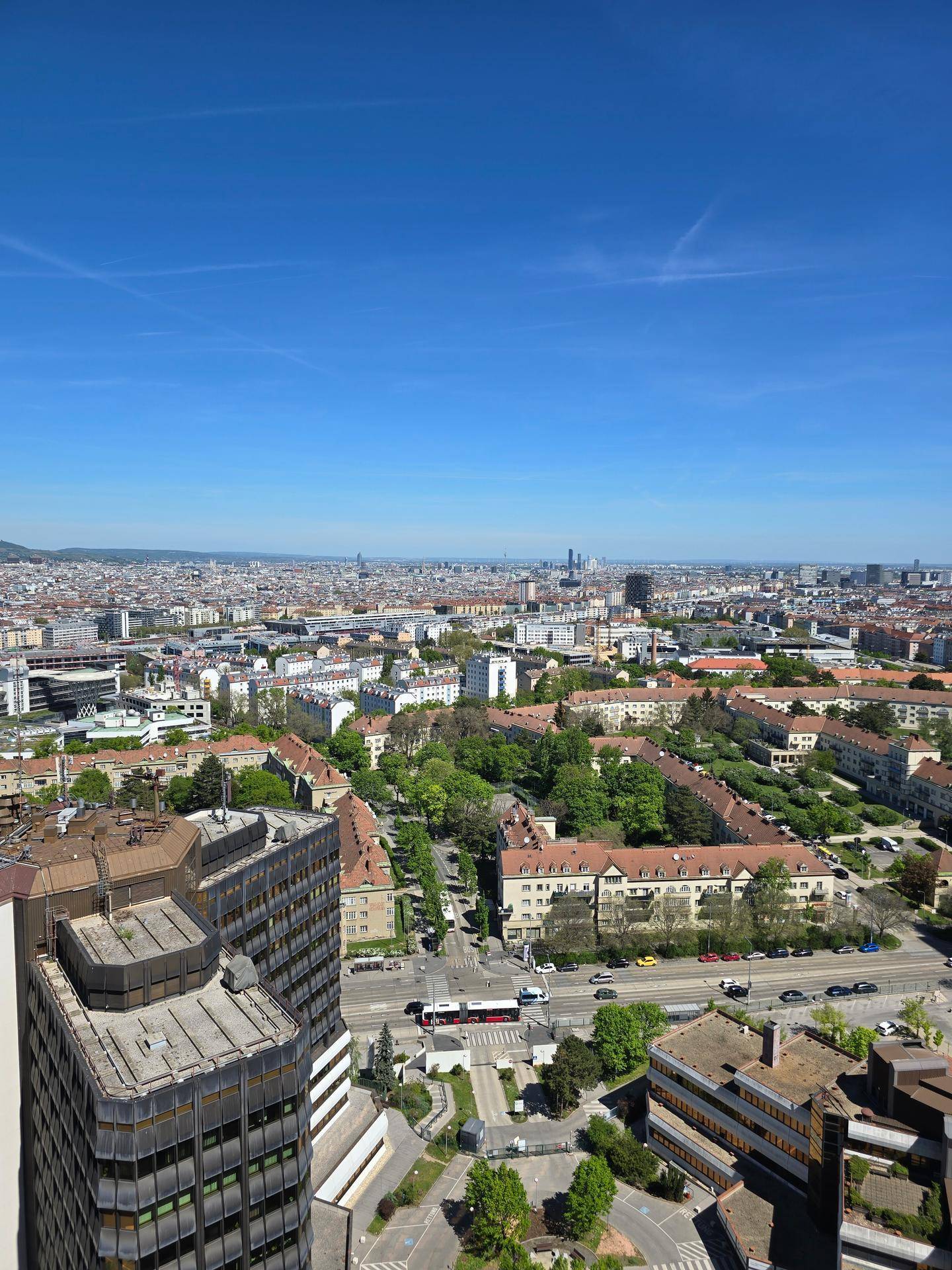 Panoramablick über die Stadt an einem sonnigen Tag mit vielen Gebäuden und Grünflächen.